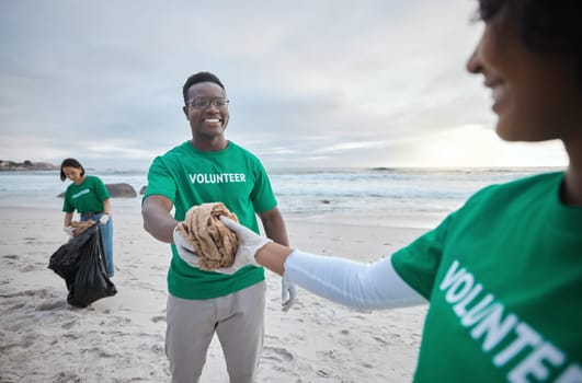 Teamwork, help and recycling with people on beach for sustainability, environment and eco friendly. Climate change, earth day and nature with volunteer and cleaning for charity and community service.
