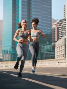 Fitness, woman and friends running in the city for cardio exercise, training or workout together in the outdoors. Happy active women enjoying a run for a healthy balanced lifestyle in Cape Town.