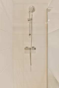 a bathroom with a shower head and hand rail in the corner of the bathtub is white tiles on the wall