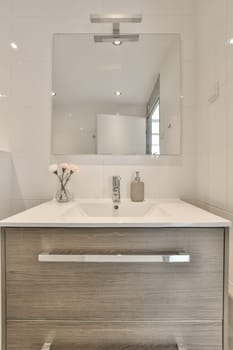 a bathroom with a sink and mirror above the counter area in front of the sink is white tiles on the wall