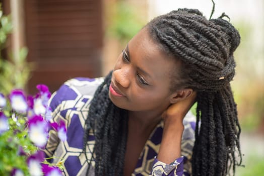 Happy young black woman smile. Stylish model. Braid dreadlock hairstyle. Joyful smiley African female in selective focus outdoors, fashion style, happiness concept. Outdoors.