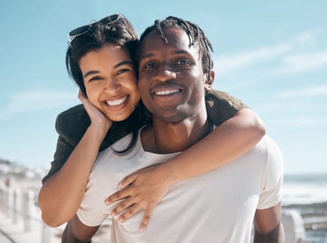 Happy couple, portrait and piggyback by beach in relax romance holiday, love vacation date or summer travel location. Smile, bonding and man carrying black woman in fun game, freedom trust or support.