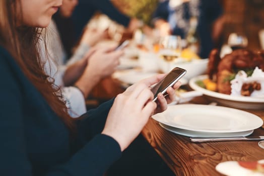 Closeup, woman and phone chatting at dinner on social media, web or app for communication at party. Girl, smartphone and internet at table, lunch or celebration in restaurant, home or thanksgiving.