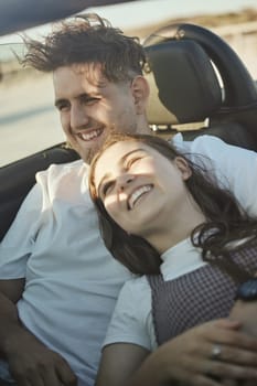 Roadtrip, travel and couple in a car on the road together, taking a drive. Love, dating and happy couple in motor vehicle hugging, laughing and smile on their face on holiday, vacation and adventure.
