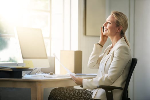 Shot of a businesswoman talking on her cellphone while sitting in her office.