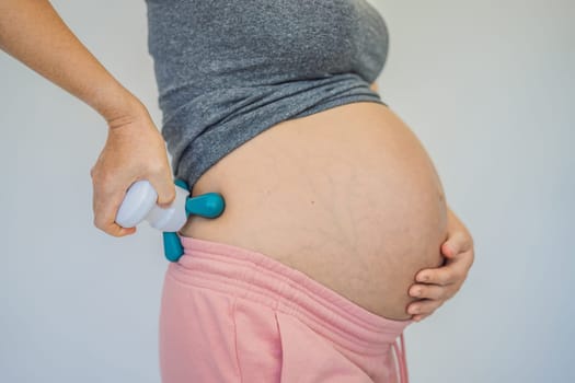 Self-massage with a massager for a pregnant woman.