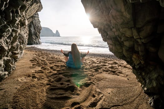 Middle aged well looking woman with black hair doing Pilates with the ring on the yoga mat near the sea on the pebble beach. Female fitness yoga concept. Healthy lifestyle, harmony and meditation.