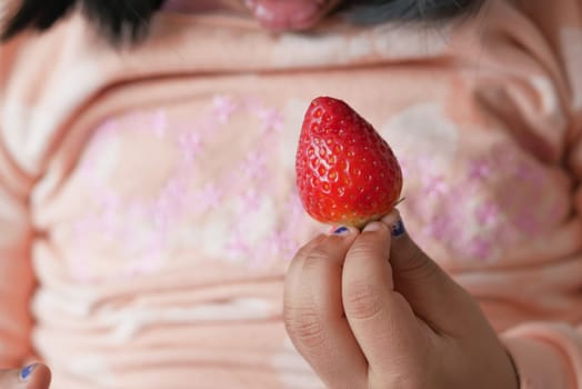 baby hand holding a Strawberry ,