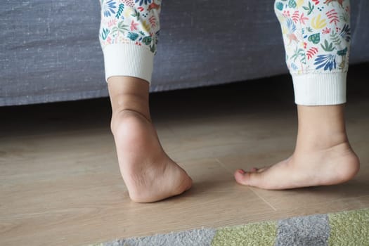 low angle view of A child walking on tiptoes.