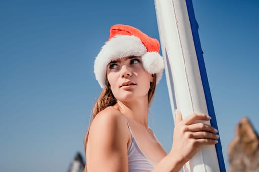 Close up shot of happy young caucasian woman looking at camera and smiling. Cute woman portrait in bikini posing on a volcanic rock high above the sea