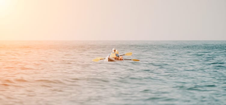 Kayaks. Couple kanoeing in the sea near the island with mountains. People kayaking in the ocean.