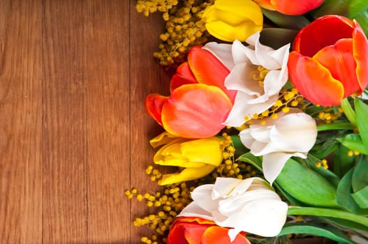 Yellow tulips, spring flowers on a wooden surface