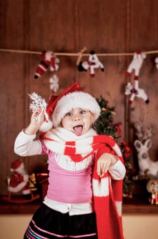 child in a suit of Santa Claus in the room decorated to new year