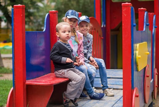 group of siblings playing together on indoor playground. Cute school kids, girls and boy playing on the colorful playground