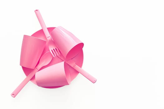 put, lay, or stand something in a specified place or position. Pink plastic camping spoons and forks isolated on white.