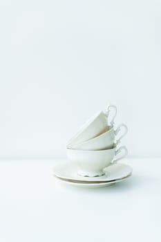 A set of cream porcelain cups with saucers on the table, preparation for the tea ceremony, top view