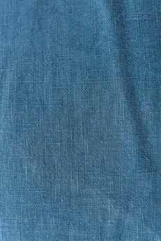 Classic blue color, vertical photo. Linen fabric blue background texture. Crumpled linen dark blue fabric