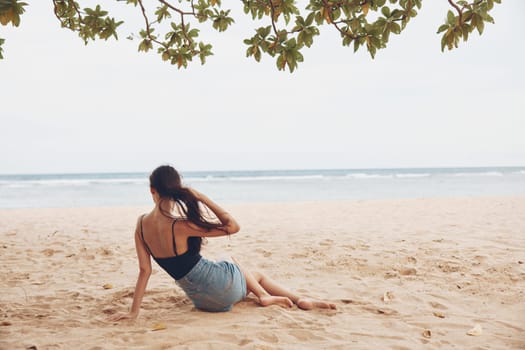 woman ocean attractive sitting vacation long view nature freedom coast smile sea relax beach carefree sand travel pretty hair alone back caucasian beauty