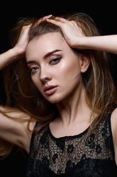 gorgeous brunette woman with long hair in black dress on black background