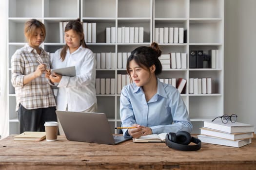 cute stylish female student, studying remotely from home, using a laptop, taking notes on notepad during online lesson, e-learning concept, smiling.