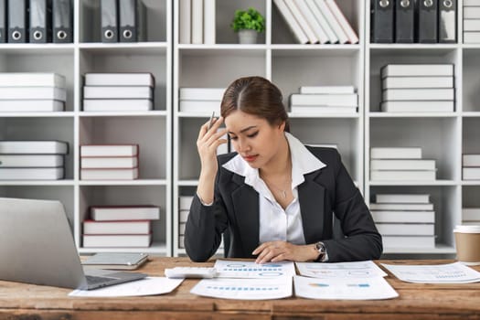 Asian business women are stressed while working on laptop, Tired asian businesswoman with headache at office, feeling sick at work.