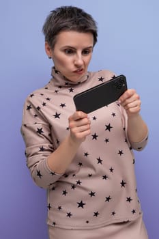 young pretty caucasian woman with short gray hair dressed in a suit of a skirt and blouse is playing on the phone.