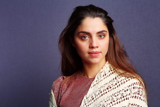 A woman wearing a beige knitted scarf.