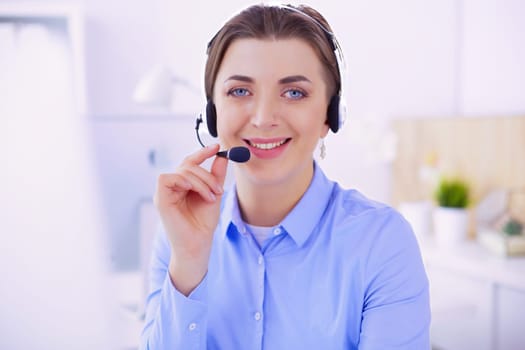 Serious pretty young woman working as support phone operator with headset in office.