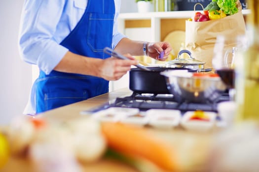 Man preparing delicious and healthy food in the home kitchen.
