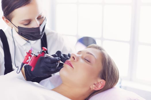 Cosmetologist applying permanent make up on eyebrows.