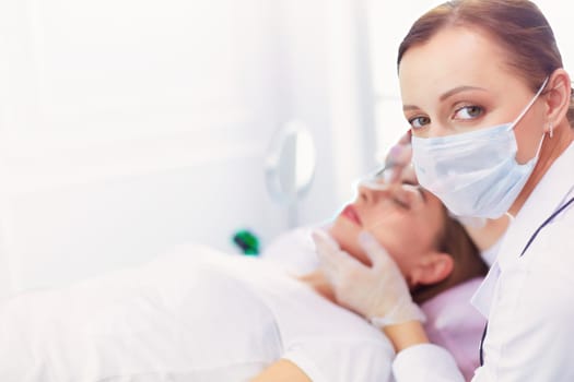 A young girl having red lips permanent makeup, micropigmentation.