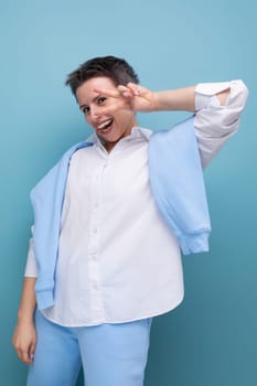 vertical photo of a stylish fashionable young lady with tousled hair in a white shirt in an informal setting.