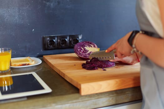Young woman using a tablet computer to cook in her kitchen.
