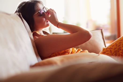 Relaxed woman sitting on a modern sofa at home.
