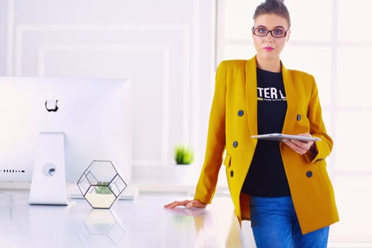 Portrait of a beautiful business woman standing near her workplace