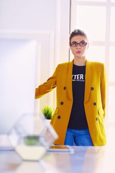Portrait of a beautiful business woman standing near her workplace