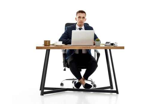 young man using laptop computer for online work at table on white background
