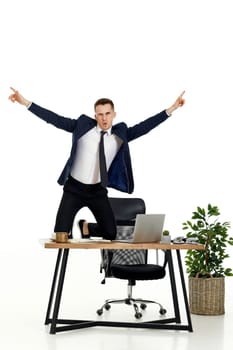 Satisfied young businessman gesturing emotionally and celebrating victory in the office