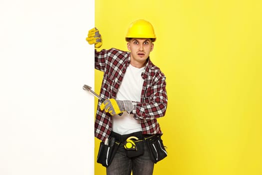 professional builder in work clothes in helmet holding hammer. copy space for text