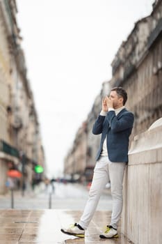 A man plays the harmonica in the street. Vertical shot