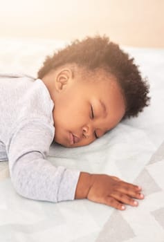 Comfort, bed and baby sleeping in home on blanket for rest, nap time and dreaming in nursery. Childcare, newborn and cute, tired and African child in bedroom sleep for comfortable, relaxing and calm.