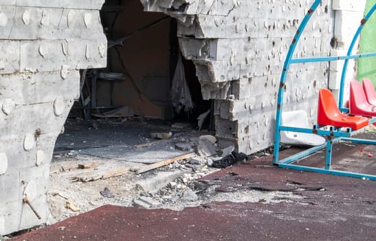 War in Ukraine. Exploded football stadium as a result of rocket attack. Broken benches for fans in the stands. Destroyed stands of the stadium. Broken fan seats