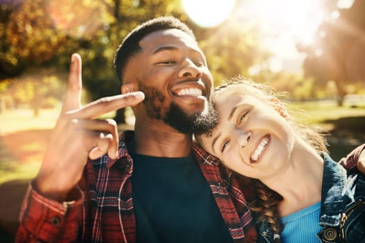 Couple smile, selfie peace sign and portrait outdoors, enjoying fun time and bonding at park. Interracial, love romance and black man and woman with v hand emoji for taking pictures for happy memory