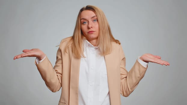 I dont know what to say. Confused businesswoman feeling embarrassed about ambiguous question, having doubts, no idea, being clueless and uncertain. Female girl in formal suit. Woman on gray background