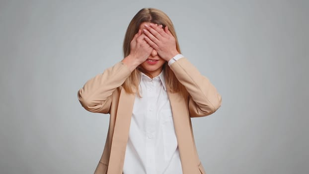 Dont want to look at this, awful. Afraid business woman closing eyes with hand showing stop gesture, confused shy scared to watch. Adult girl isolated on gray studio background. People lifestyles