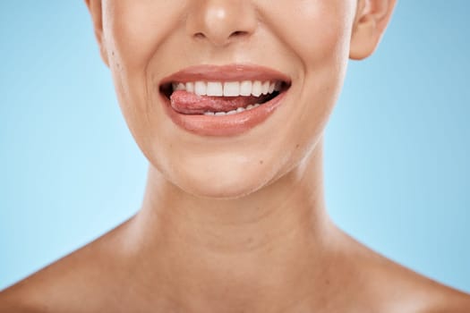 Dental, health and woman with a smile in a studio for hygiene, wellness and natural oral routine. Healthy, veneers and closeup of female model with clean, beautiful and white teeth by blue background.