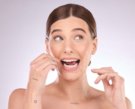 Flossing, woman and teeth in studio for beauty, healthy dental wellness and skincare on background. Female model, tooth floss and cleaning mouth for fresh breath, oral maintenance or cosmetic results.