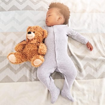 Top view, teddy bear and baby sleeping in bed for rest, nap time and dreaming in nursery. Childcare, newborn and cute, tired and African child with toy in bedroom sleep for comfort, relax and calm.