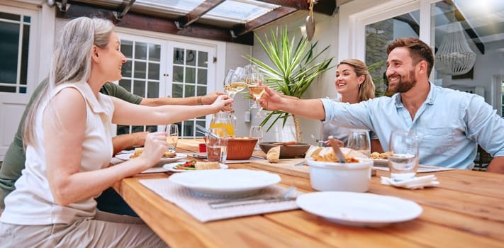 Friends, wine and celebration toast with family to celebrate holiday with lunch party, food and wine at patio table. Men and women couple drinking alcohol together and happy while talking home.