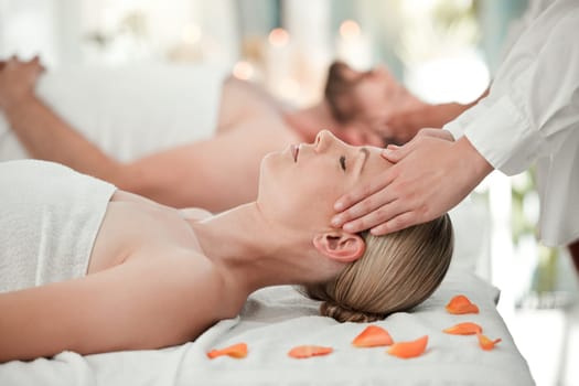 Woman, spa and massage on head while on bed with flowers for relax, wellness and calm on vacation. Luxury, health and physical therapy for couple at hotel, salon and hands on scalp for natural care.